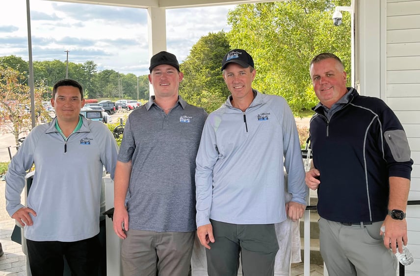 A group of Town Dock team members in golf shirts standing outside