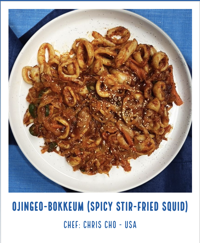 A white plate of spicy stir-fried calamari rings and cabbage with sesame seeds